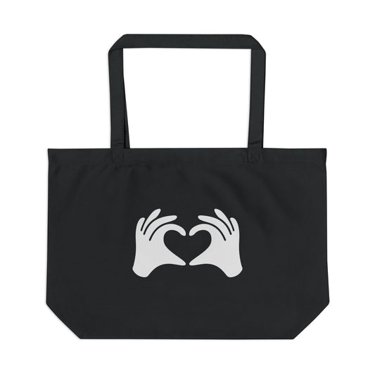 Black tote bag with white hands forming a heart design on a white background