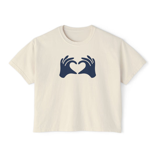 Beige t-shirt with navy blue graphic of hands forming a heart on a white background