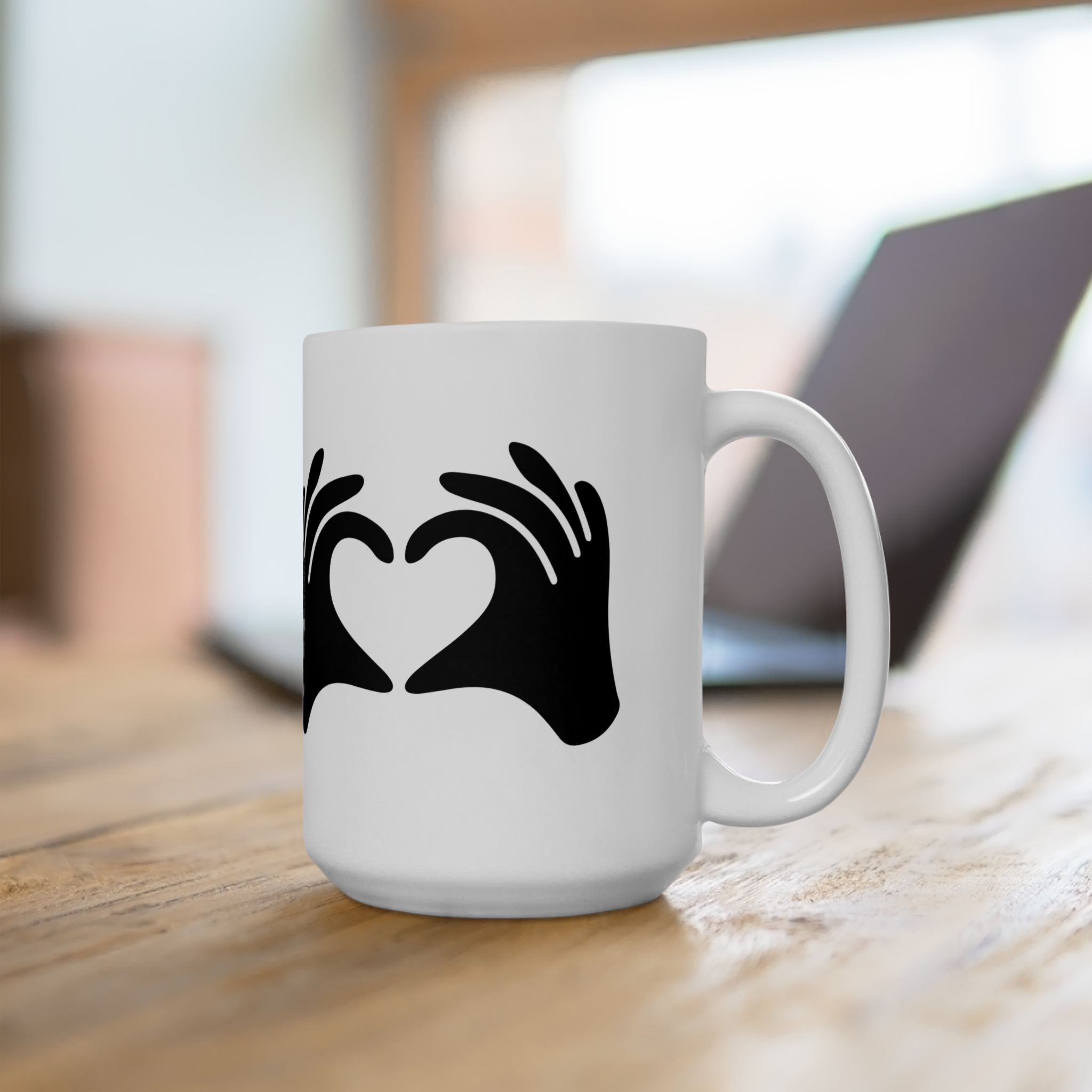 White mug with black heart design on a wooden surface