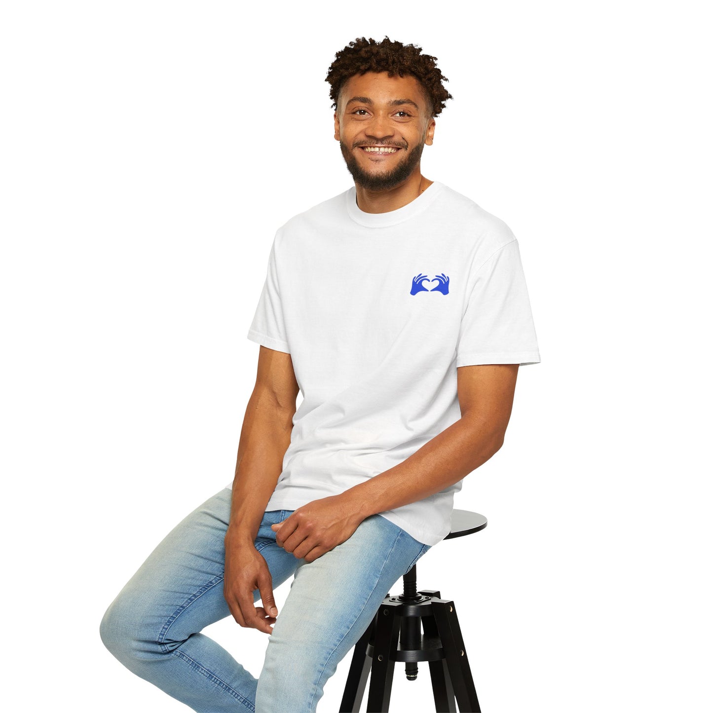 Man sitting on a stool wearing a white t-shirt with 'Why So Serious?' text.