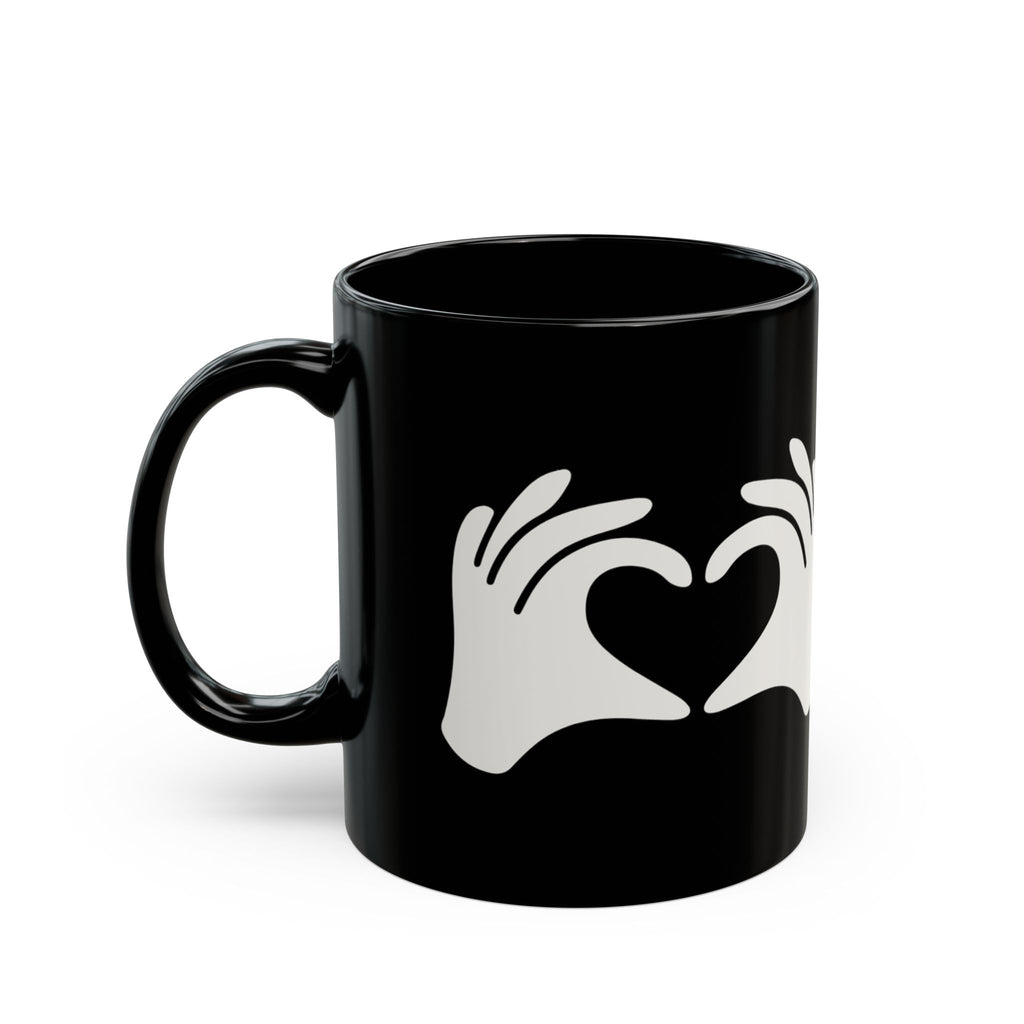 Black mug with white hand and heart design on a white background