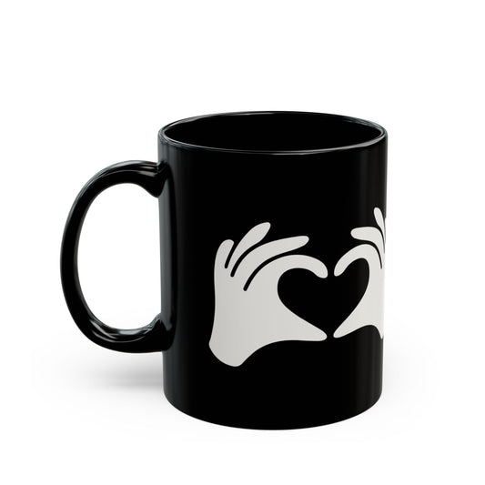 Black mug with white hand and heart design on a white background