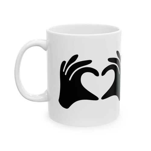 White mug with black hand-shaped heart design on a white background
