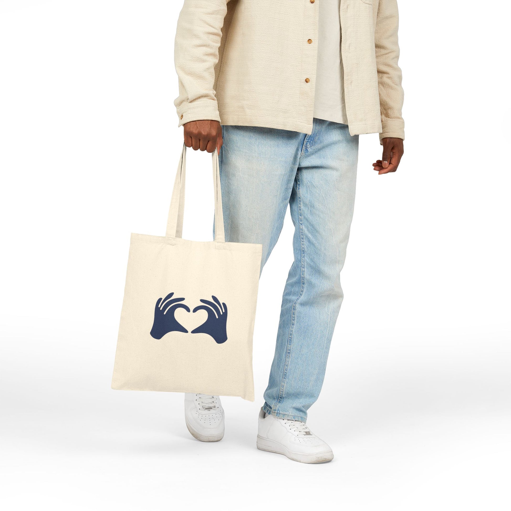 Person holding a tote bag with 'Rooted in Christ' text on a white background