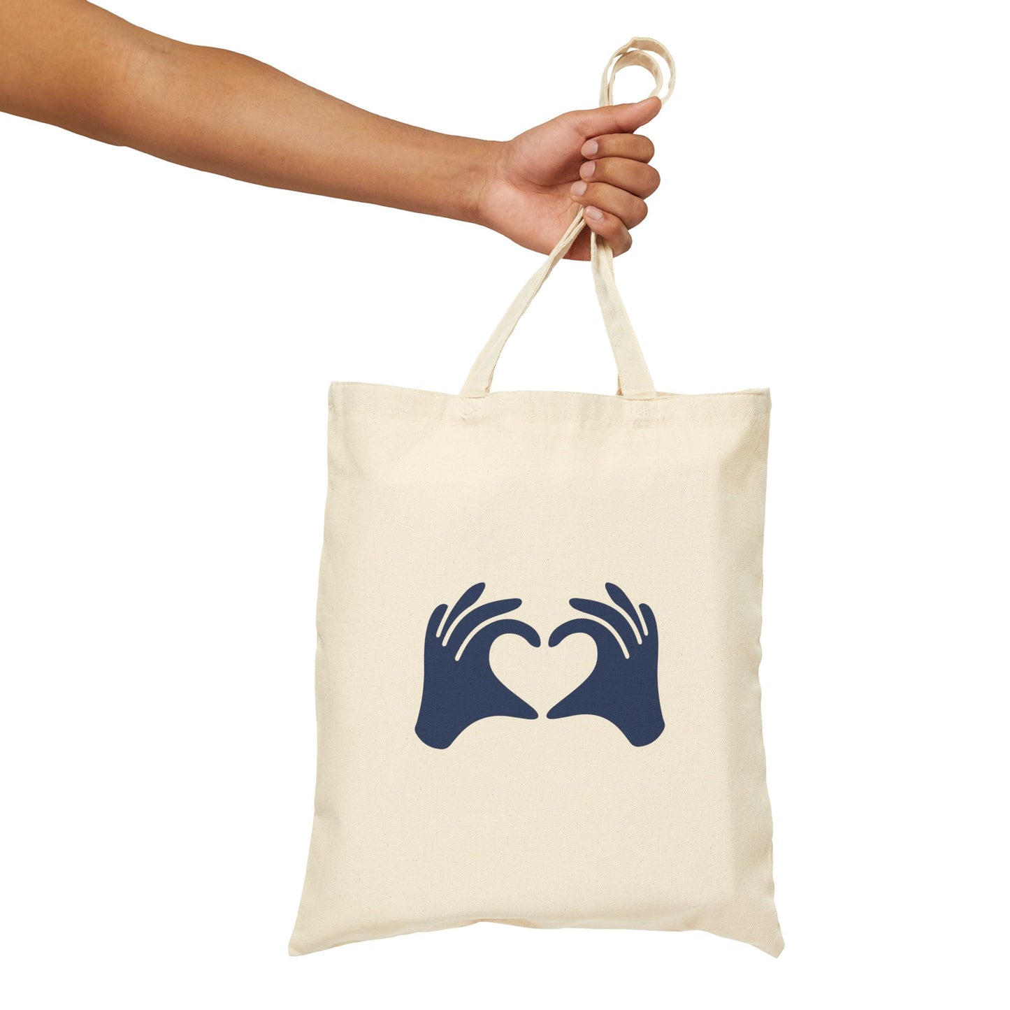 Tote bag with hands holding a heart design held by a hand on a white background