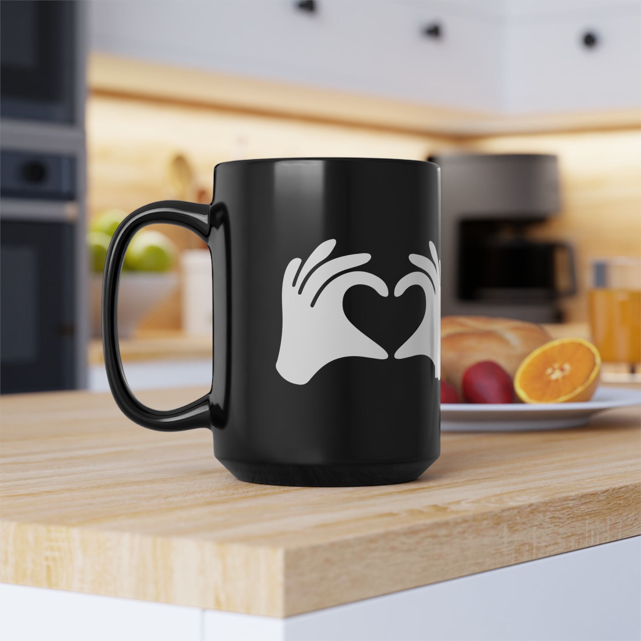 Black mug with a heart and hands design on a kitchen counter