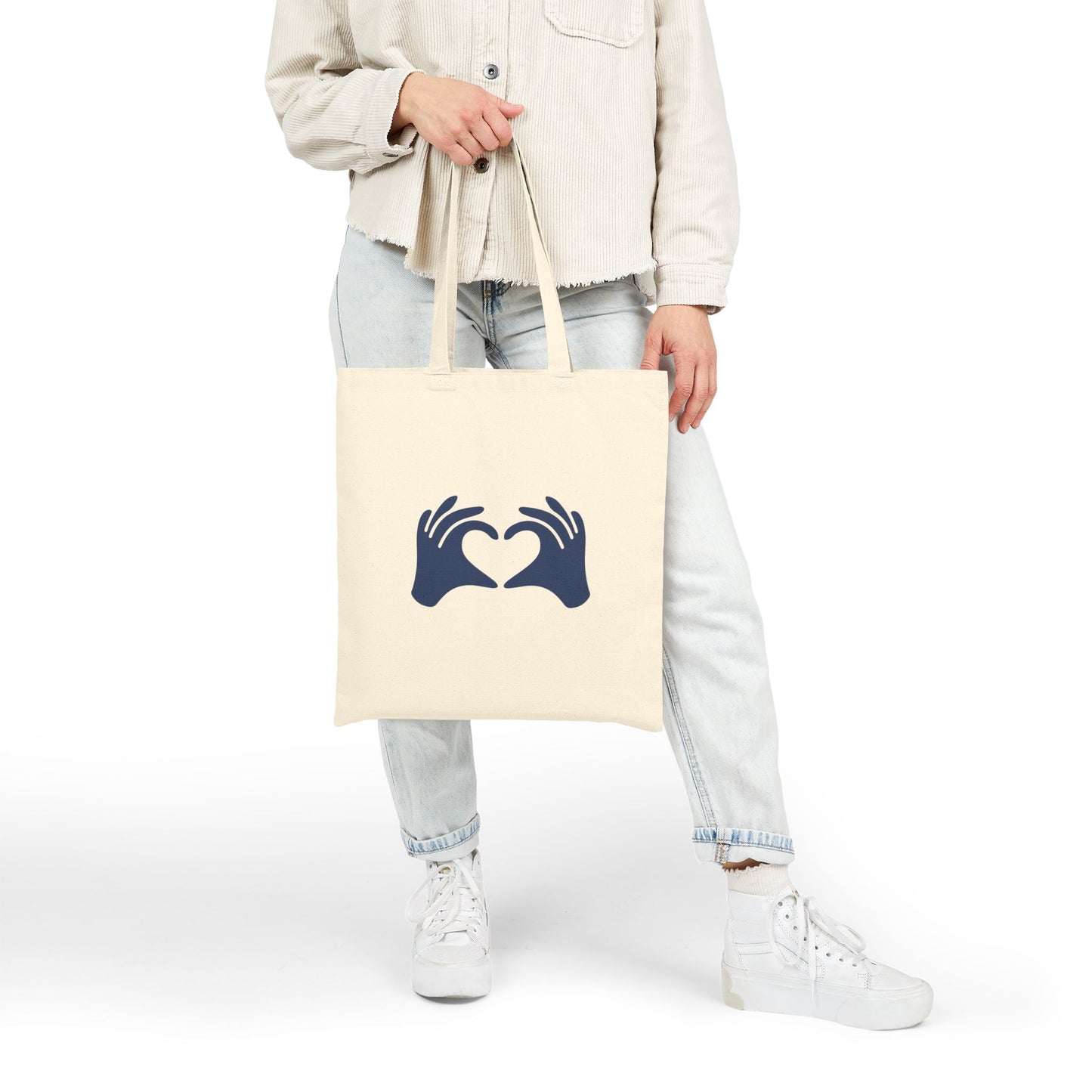 Person holding a tote bag with text and graphics on a white background