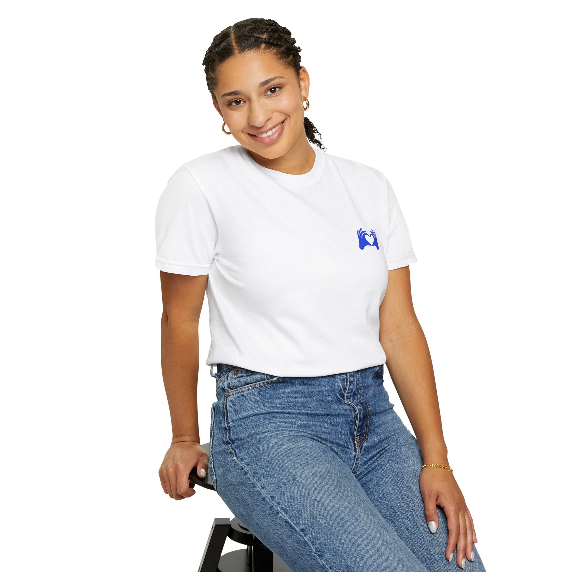 Person wearing a white t-shirt and blue jeans sitting on a stool against a white background