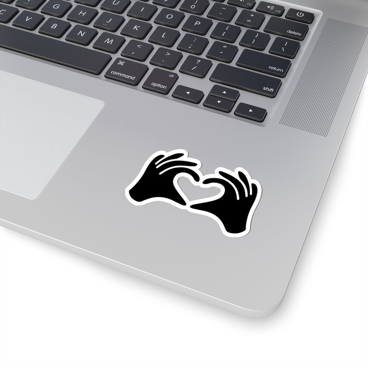 Laptop with a black sticker featuring Arabic text on a white surface